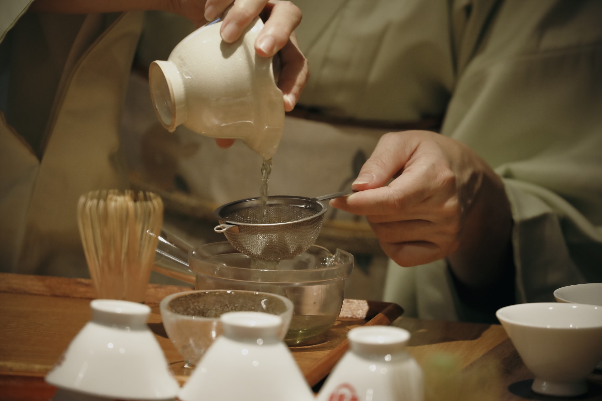 a person pouring liquid into a strainer