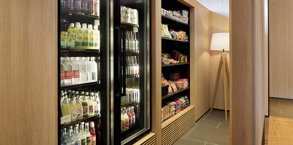 two refrigerators filled with drinks next to shelves filled with snacks