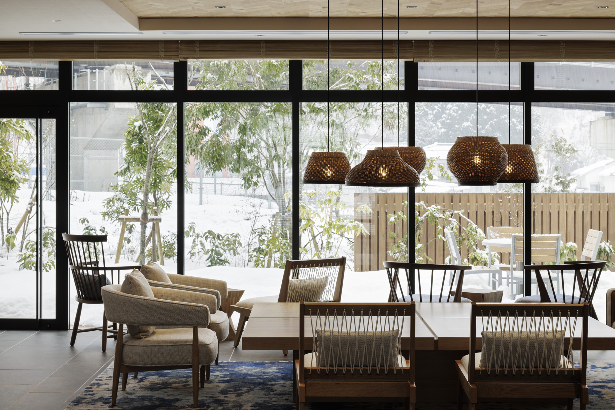 a room with a table and chairs and a large window