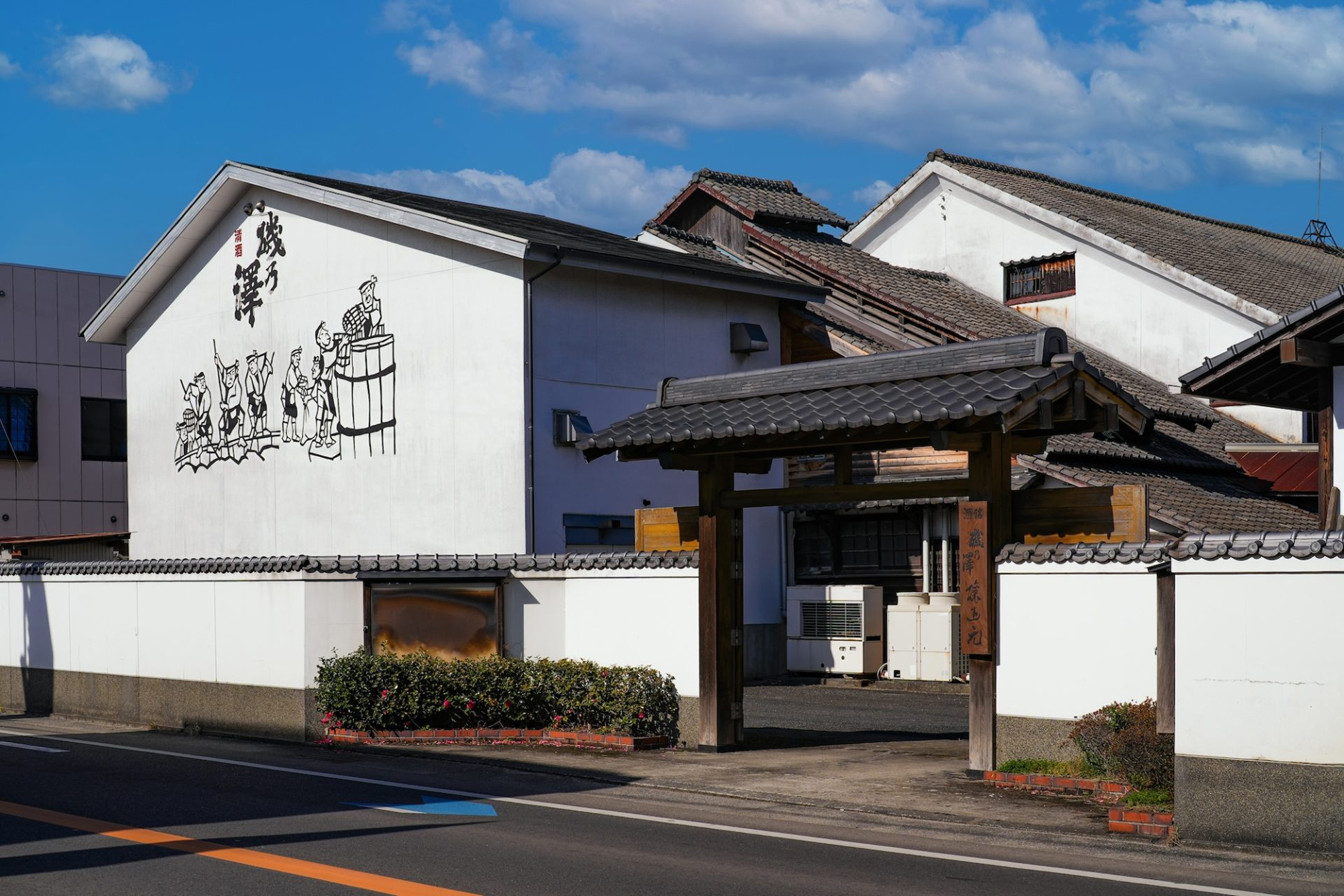 a white building with a gate and a street
