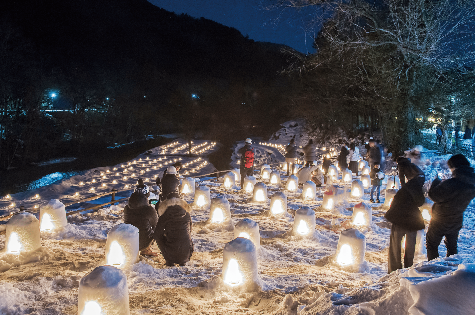 people sitting in snow with lights on