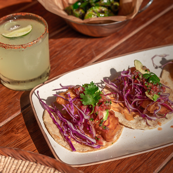 a plate of tacos and a drink