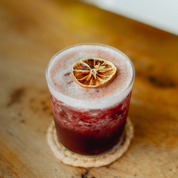 a glass with a drink and a slice of lemon on top