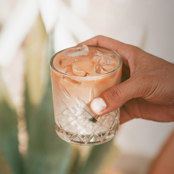 a hand holding a glass of ice