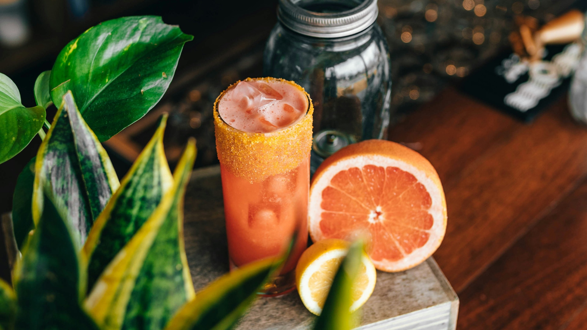 a glass of orange juice next to a jar of fruit