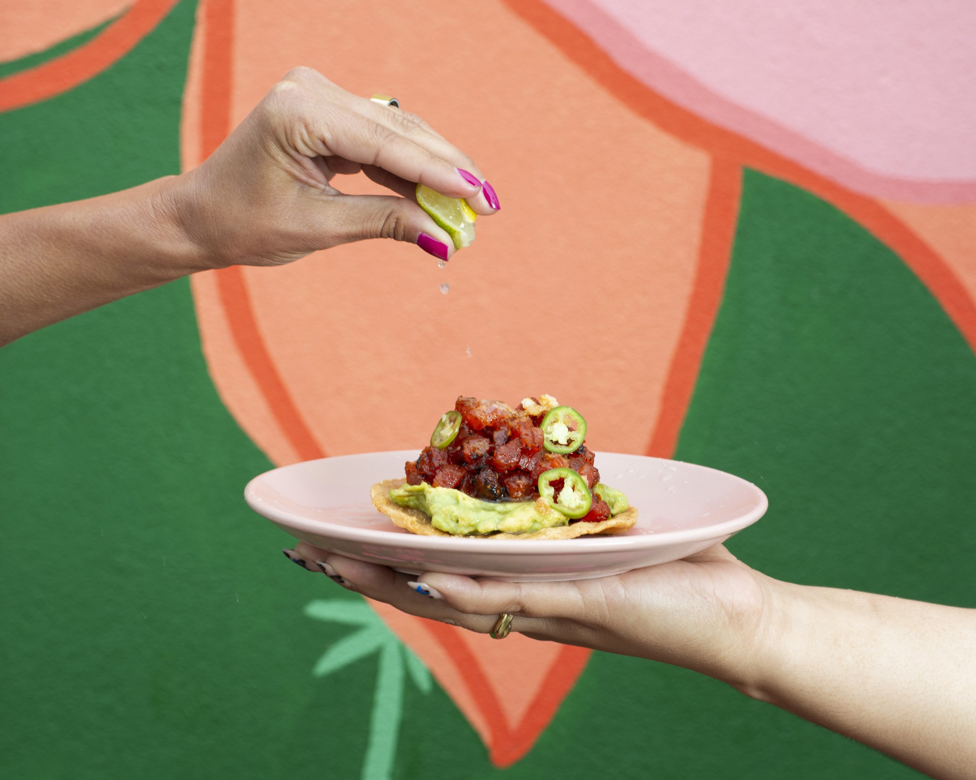 a person pouring a lemon onto a plate of food
