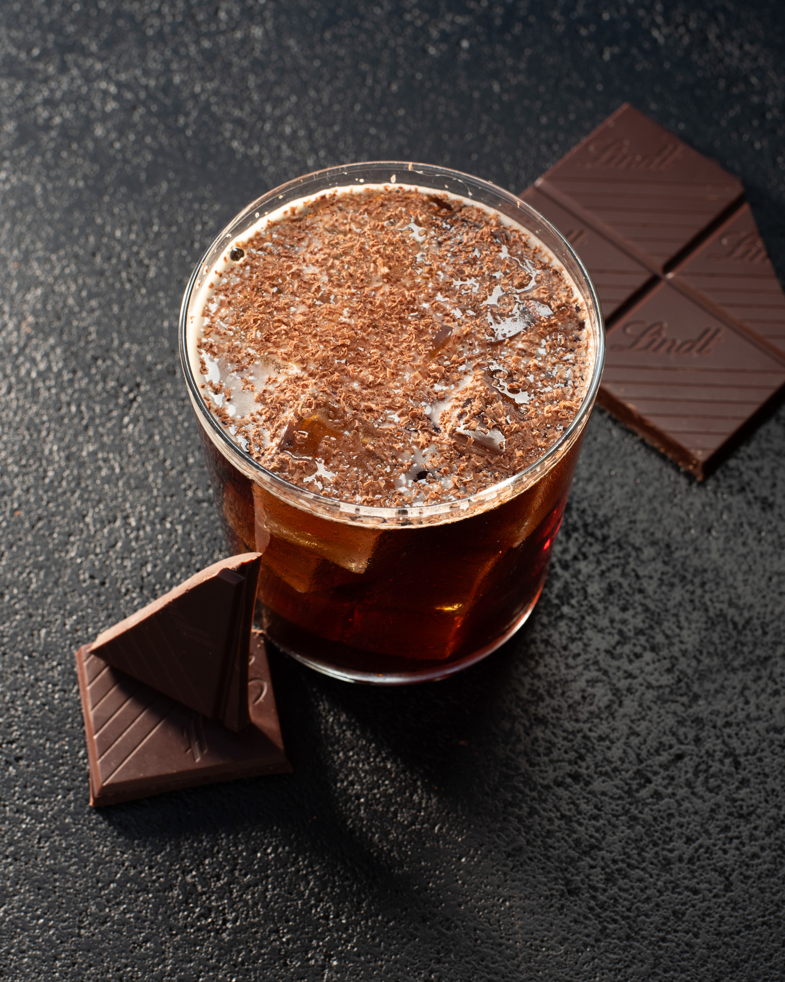 a glass of liquid with a chocolate bar