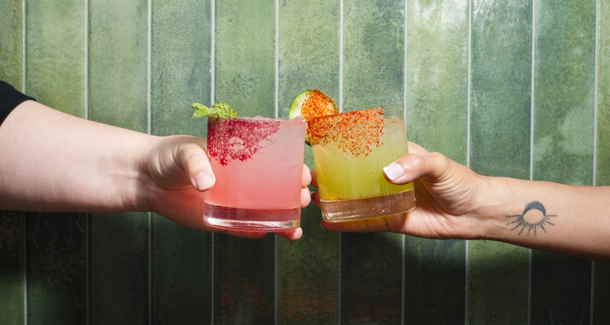 two hands holding drinks