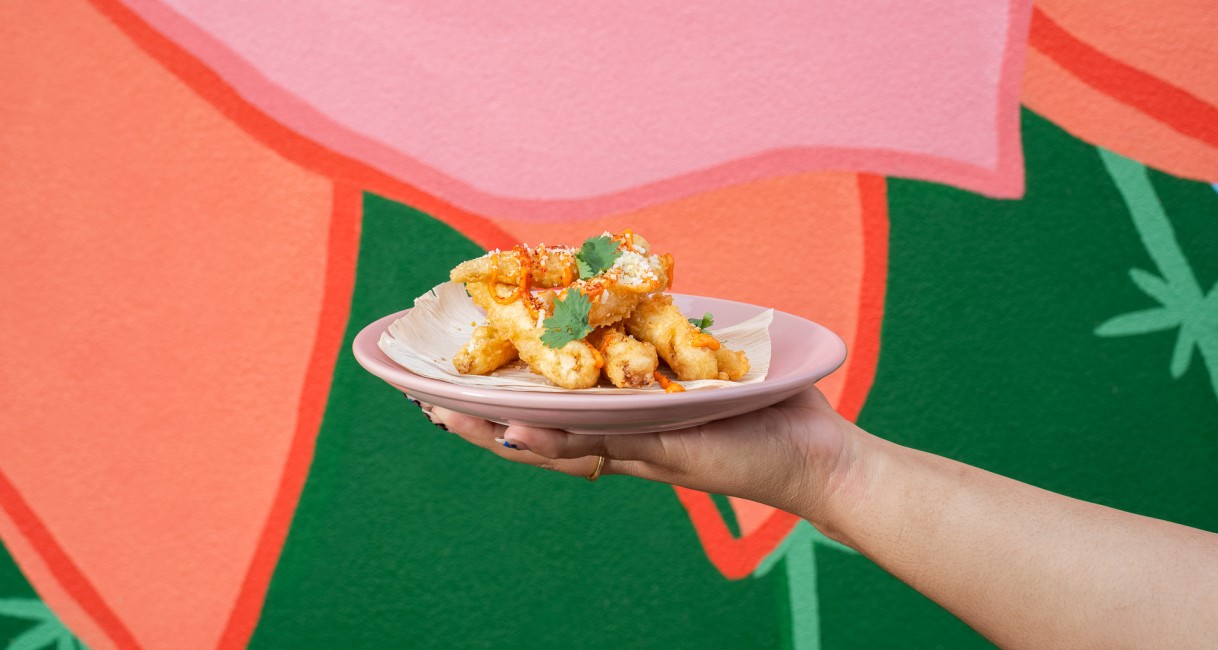 a hand holding a plate of food
