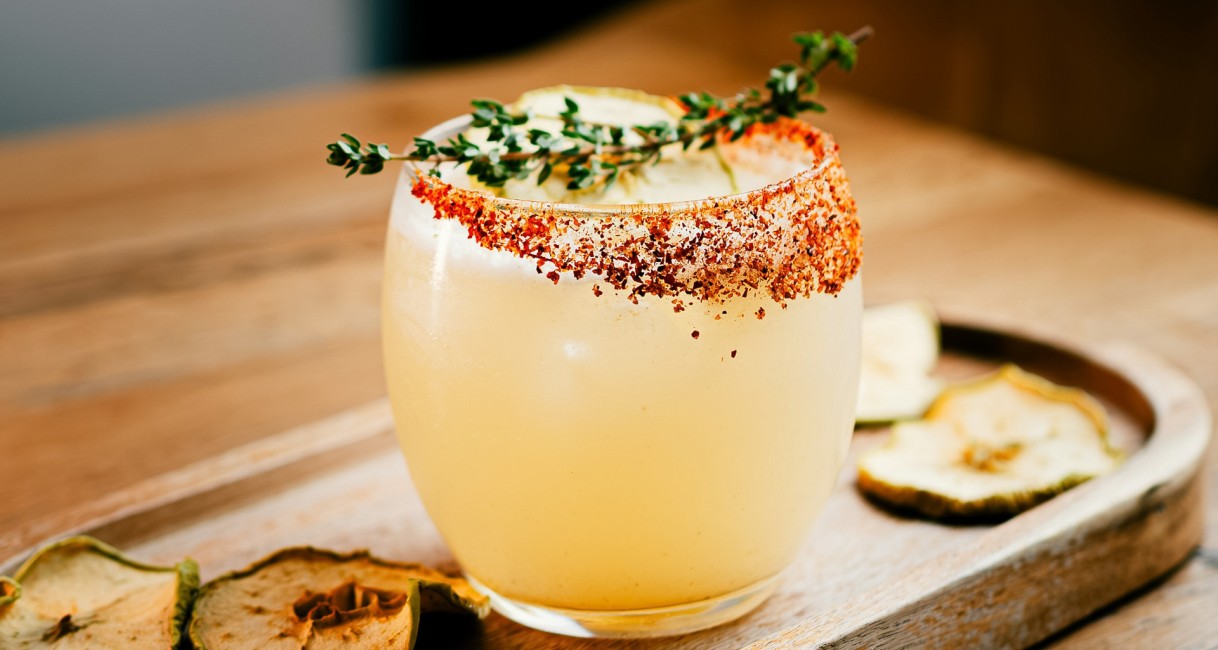a glass with a drink and a sprig of thyme