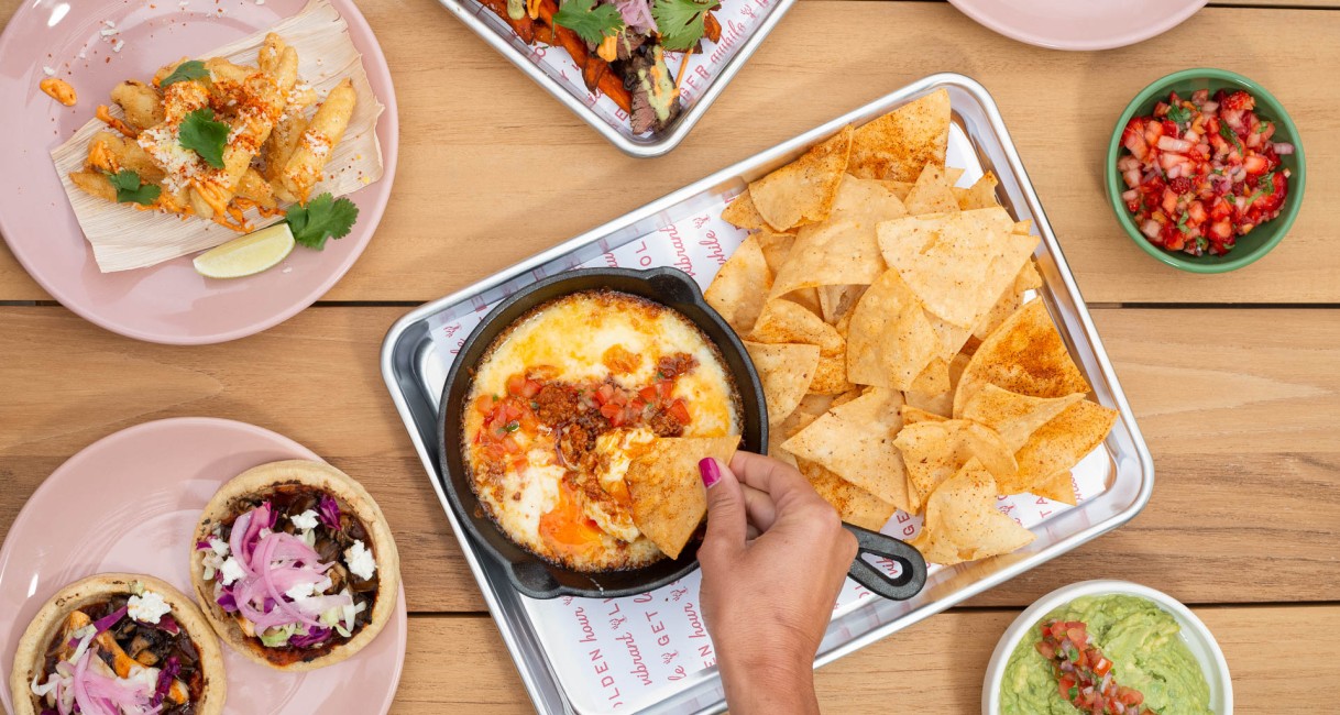 a person dipping food into a pan
