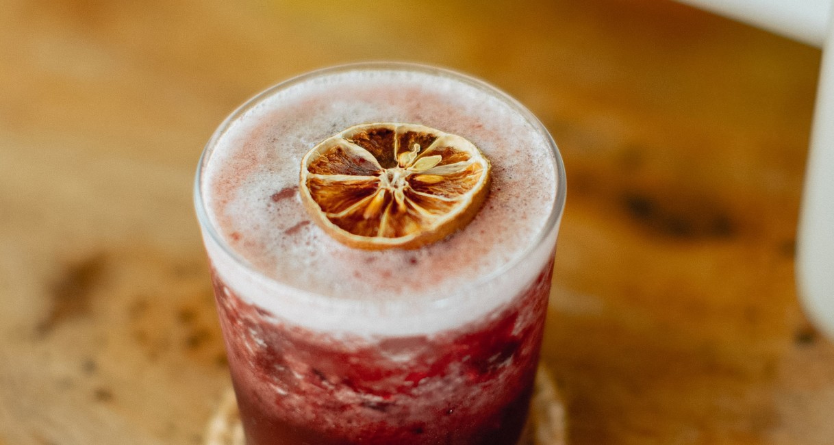a glass with a drink and a slice of lemon on top
