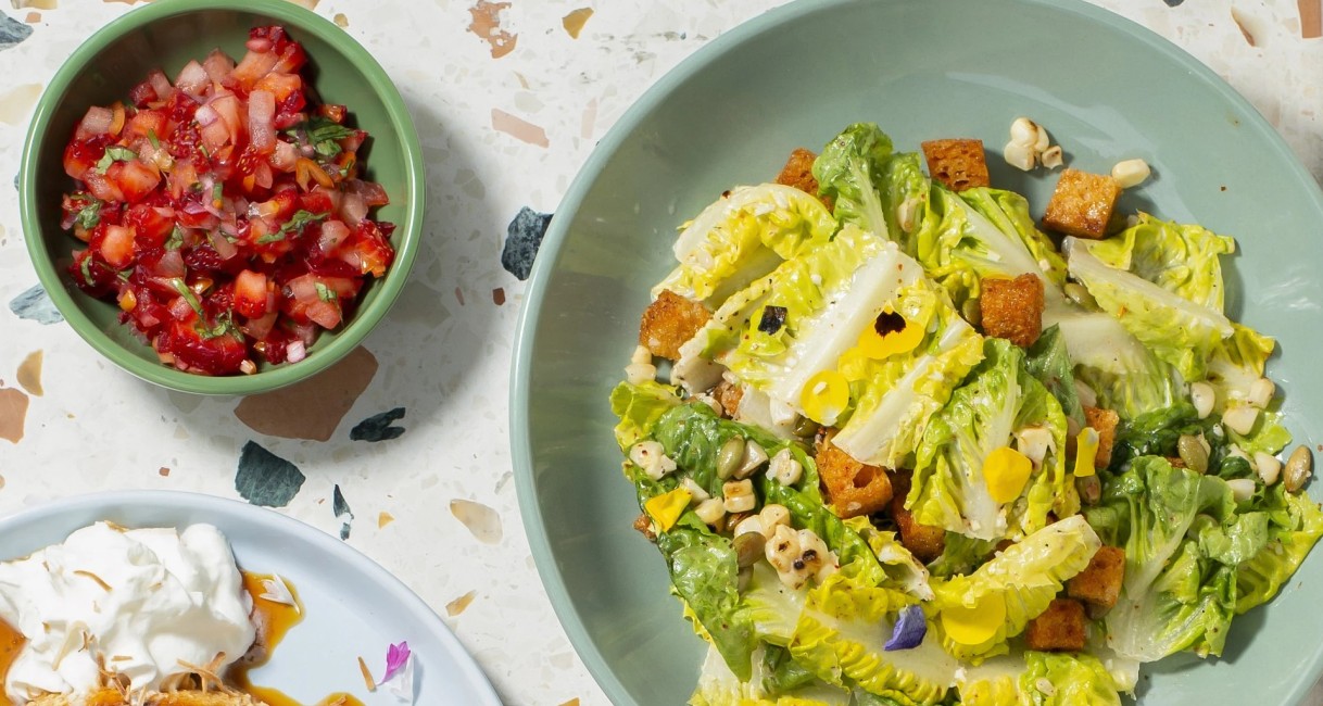 a salad in a bowl next to a bowl of salsa