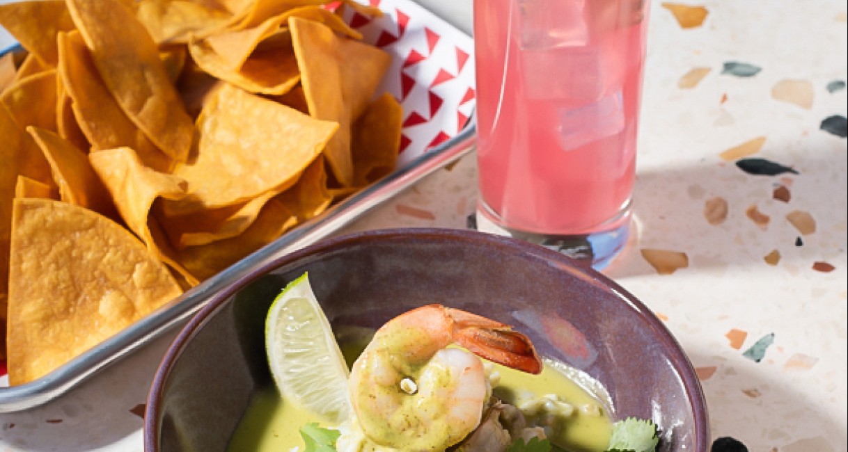a bowl of food next to a drink
