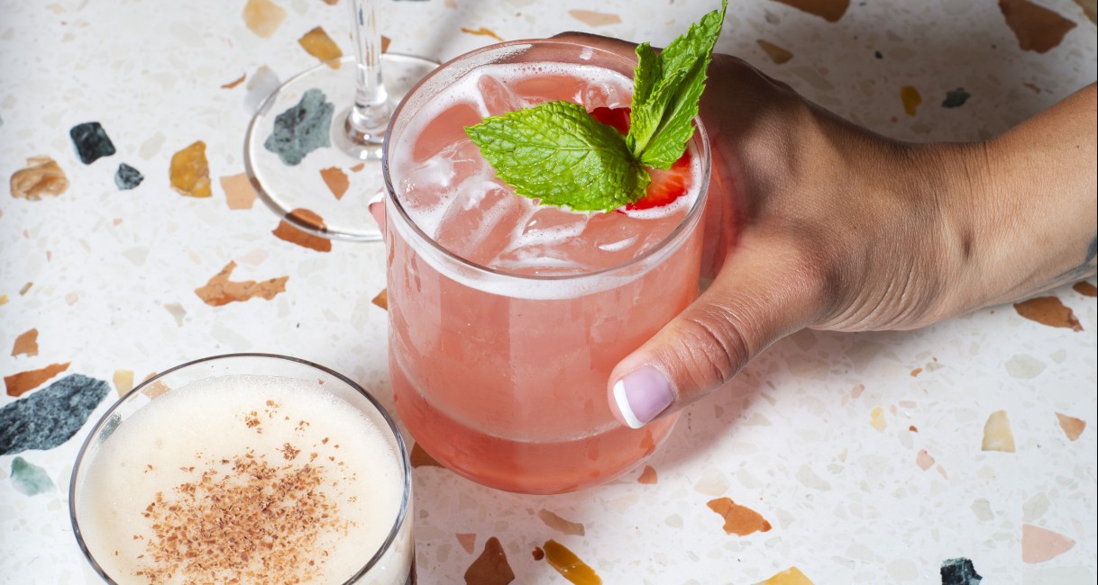 a hand holding a glass of liquid