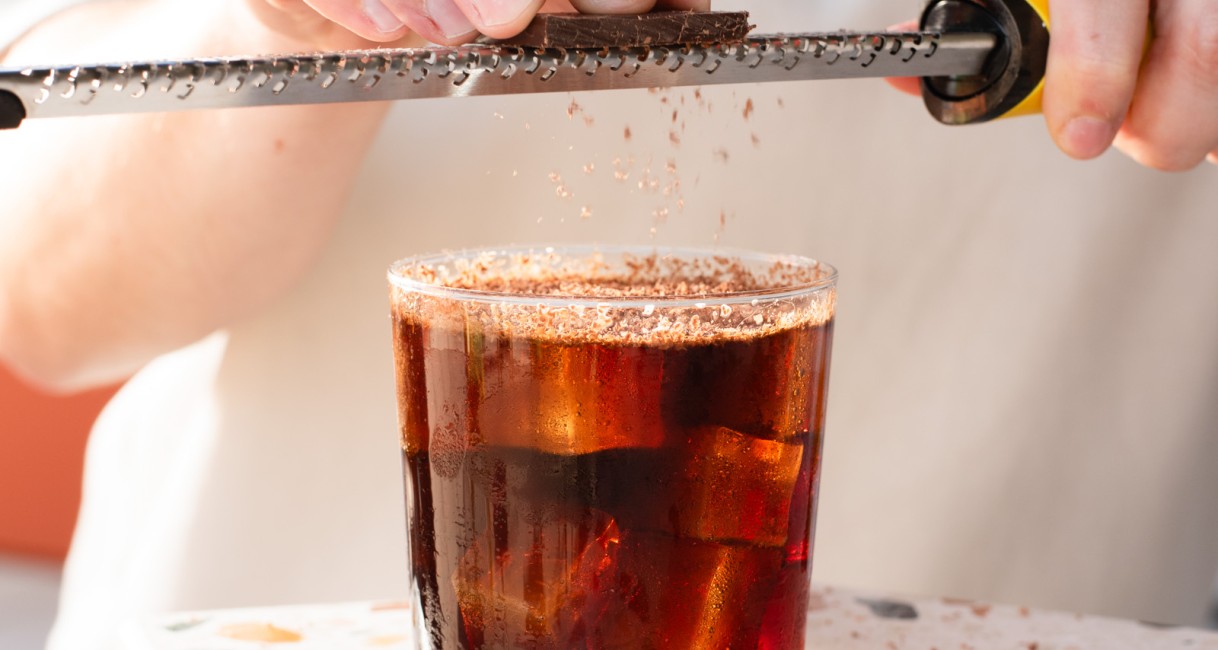 a person using a grater to grate a glass of liquid