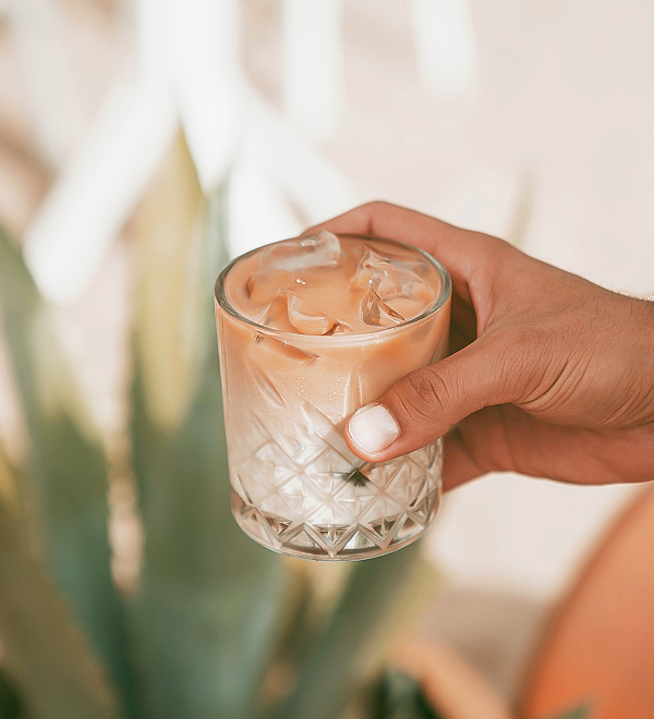 a hand holding a glass of ice
