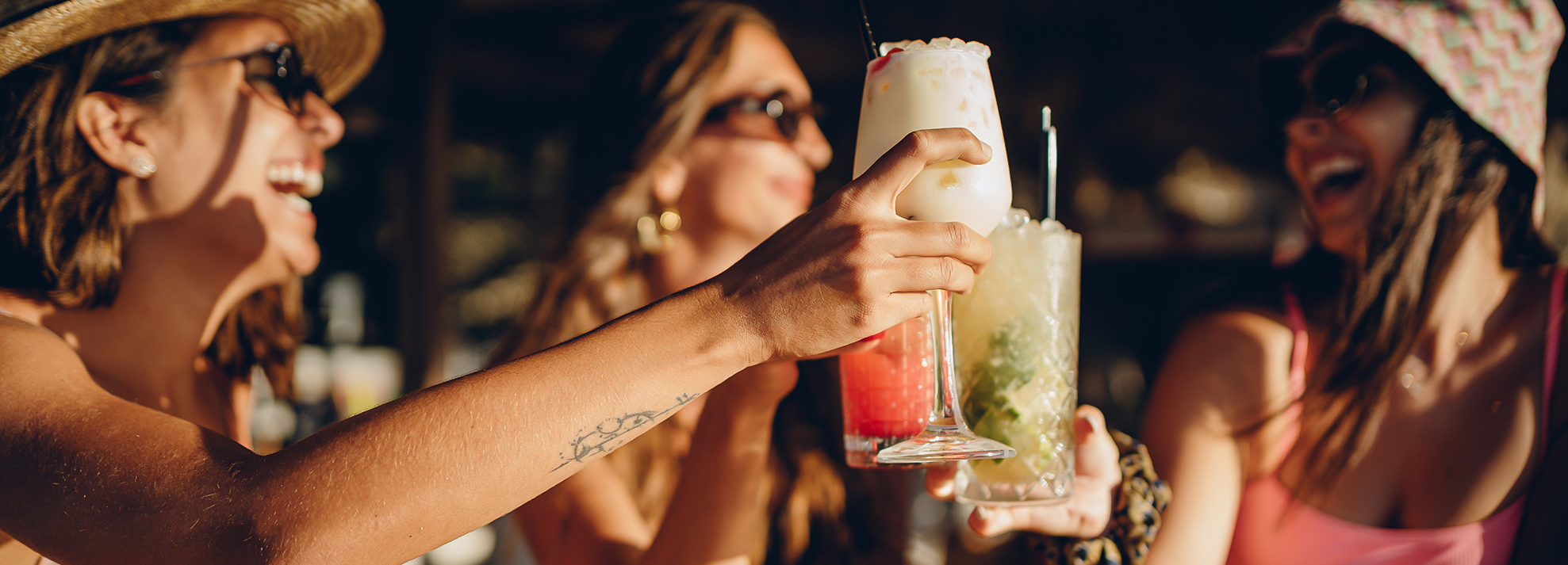 a woman holding drinks in a glass