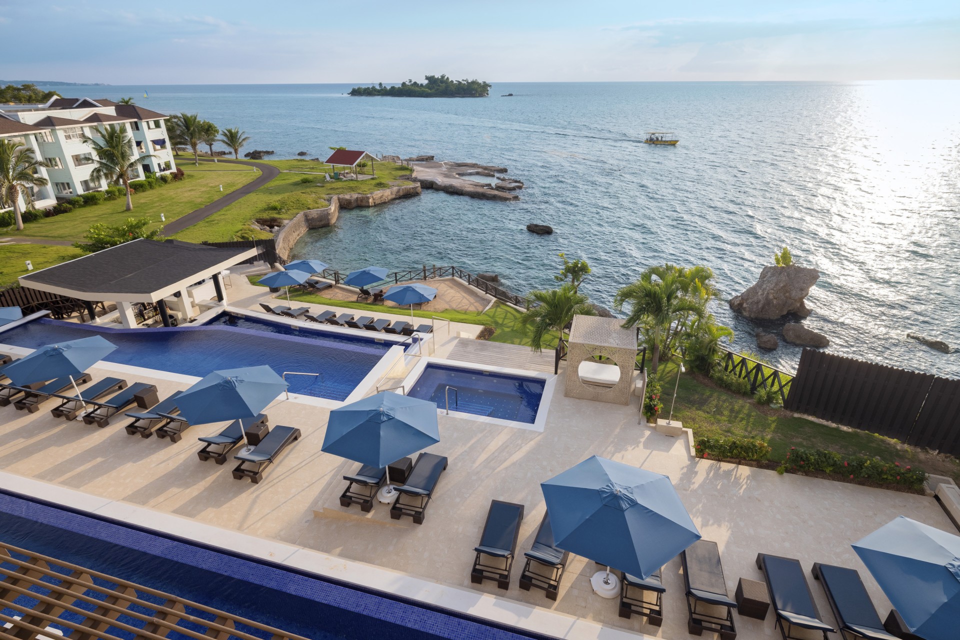 a swimming pool and umbrellas by a body of water