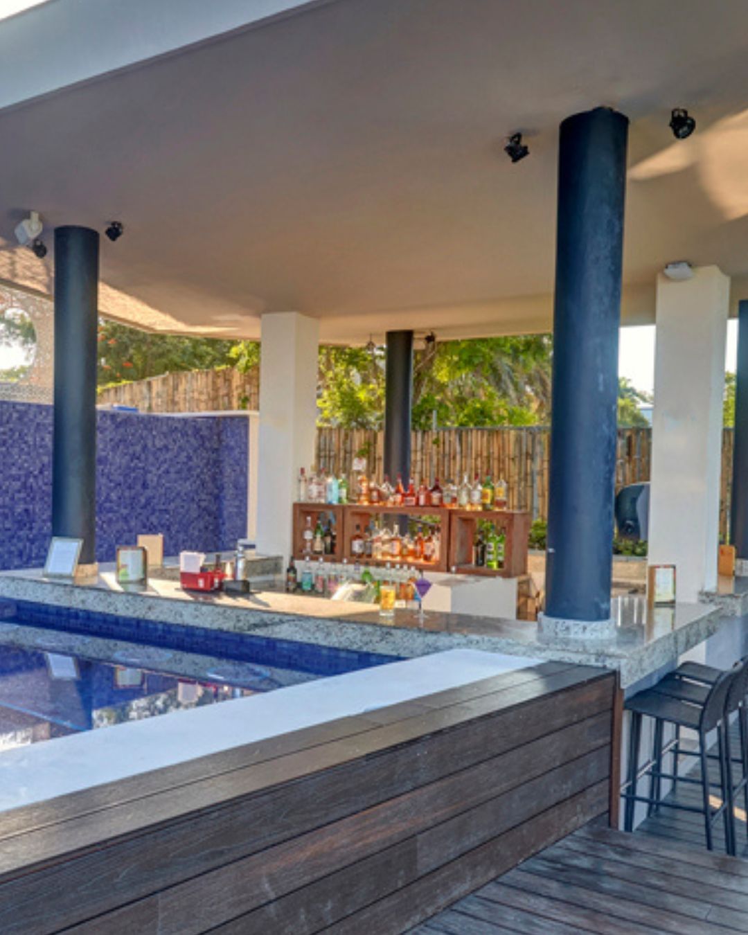 a bar with drinks and a pool