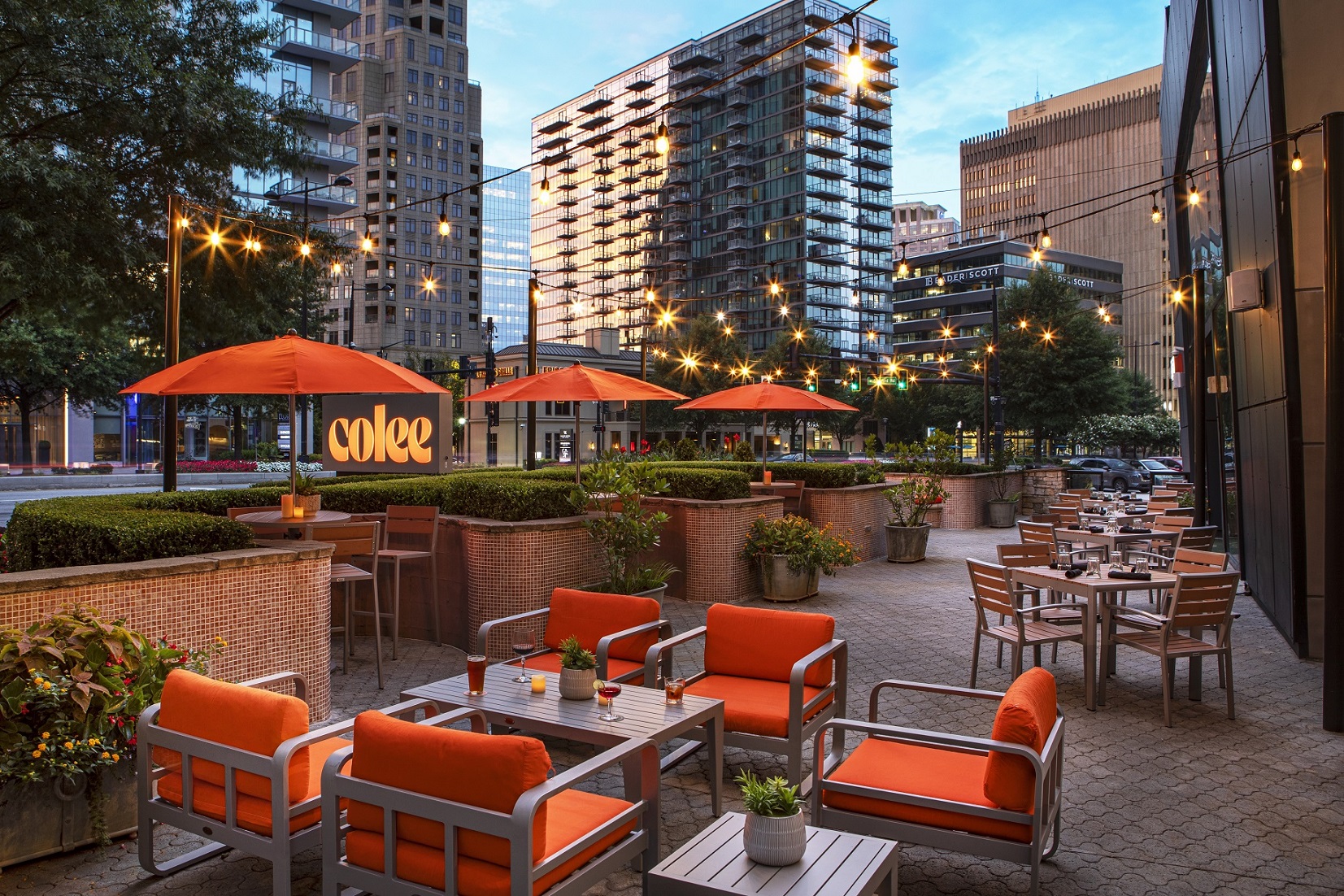 a patio with tables and chairs and umbrellas in a city