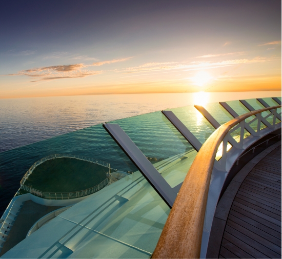 a deck of a cruise ship with a sunset in the background