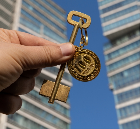 a hand holding a key with a coin and a key chain