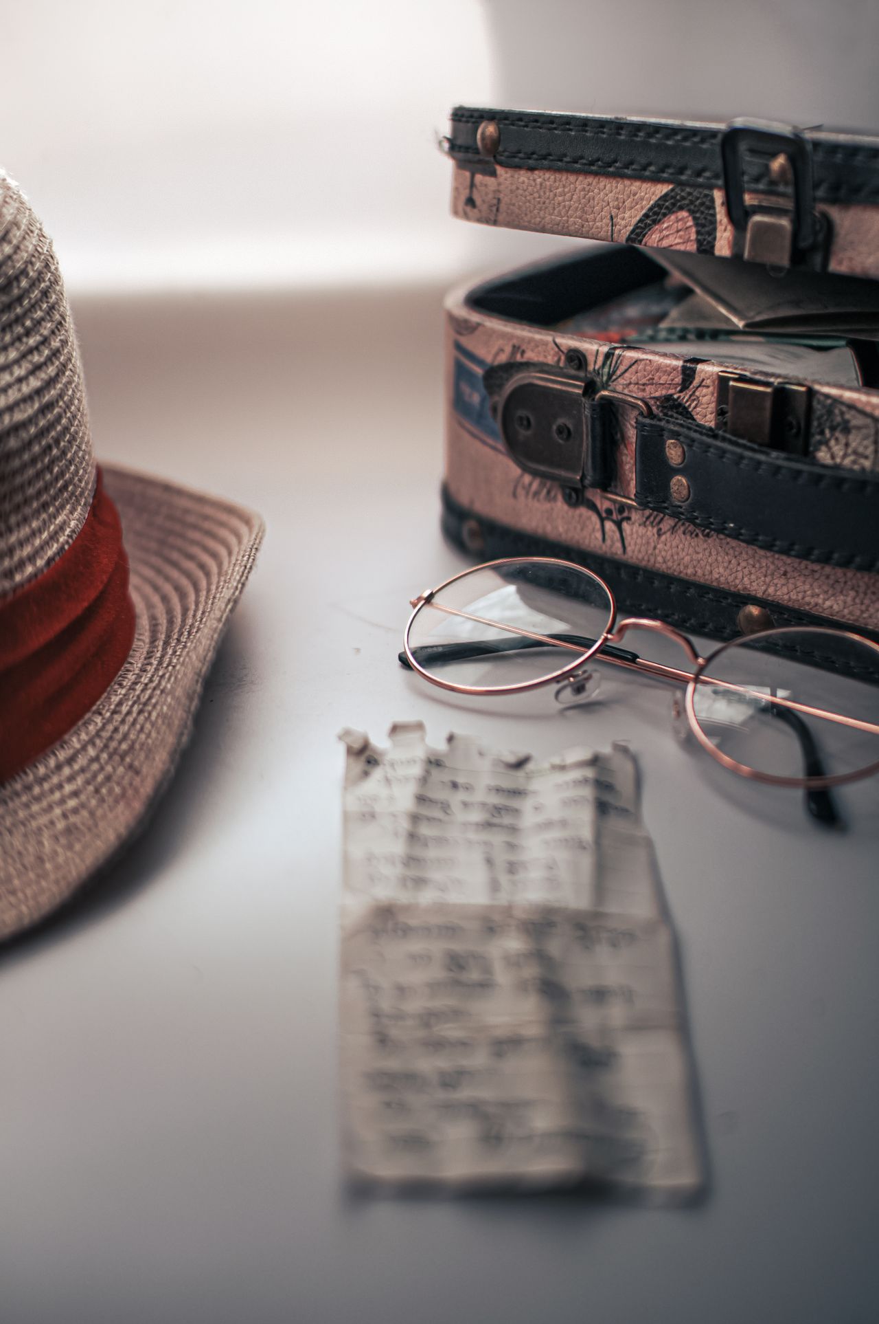 a hat and glasses near a vintage suitcase