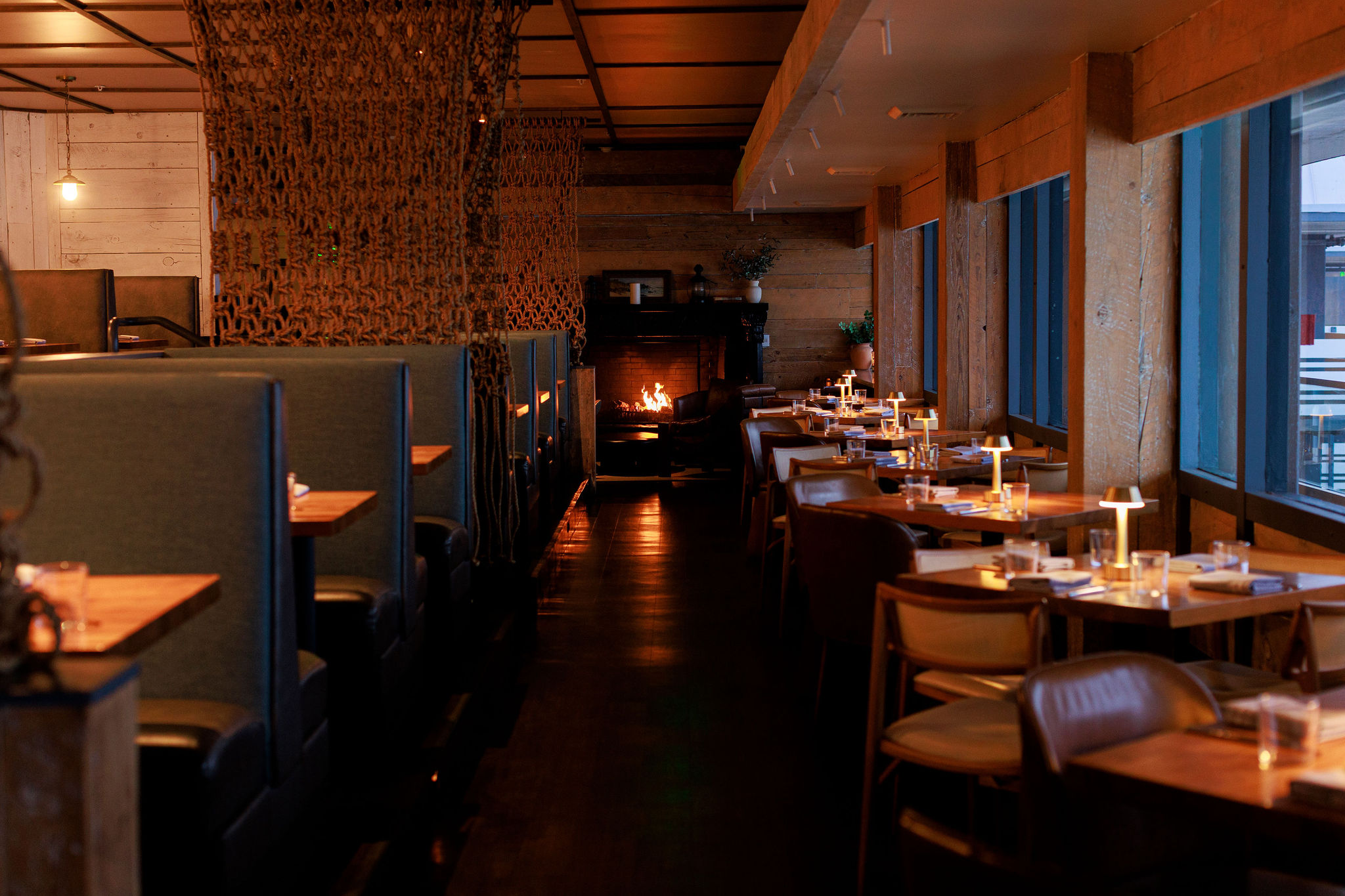a room with tables and chairs and a fireplace