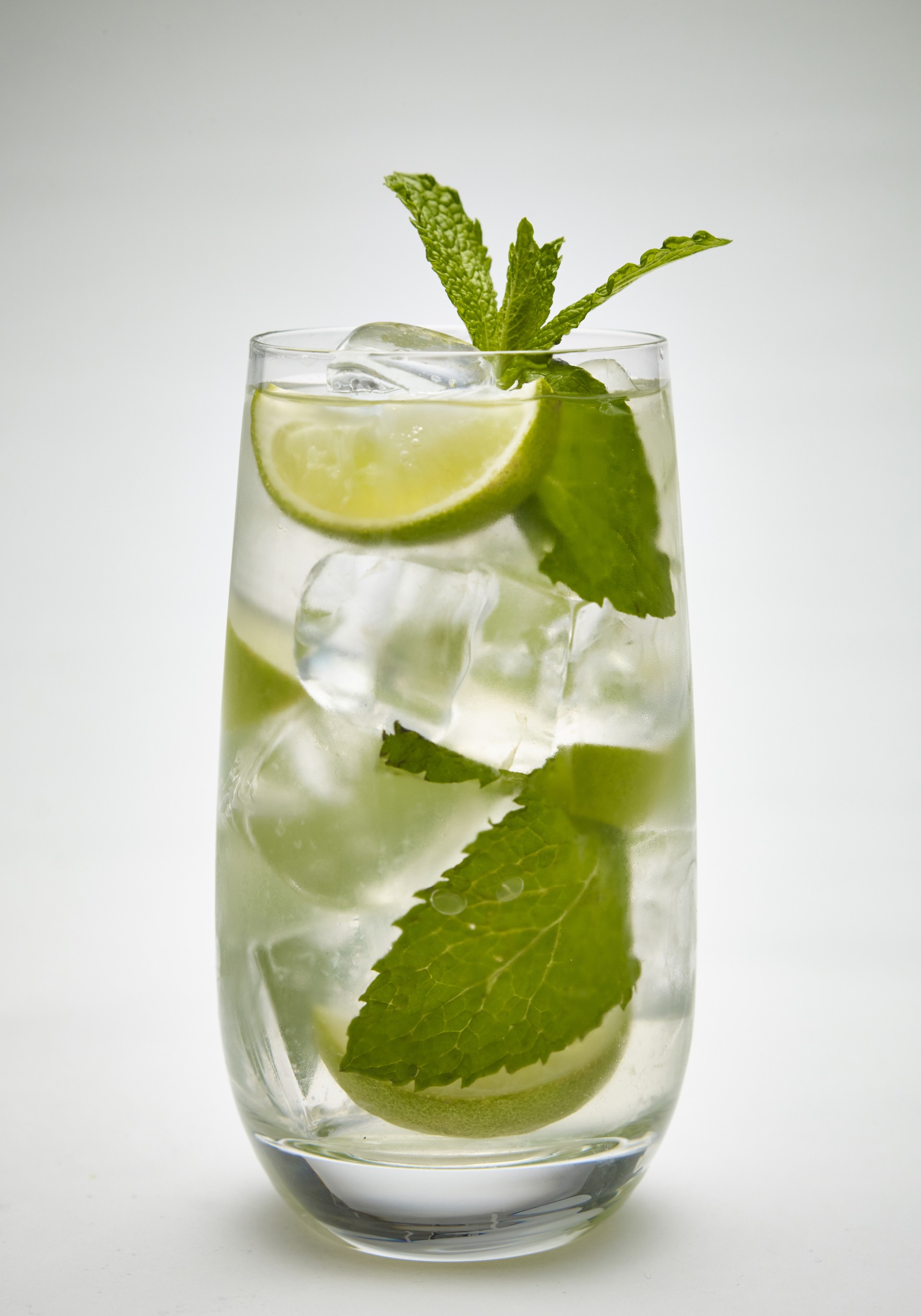 mojito a glass with ice and lime slices and mint leaves
