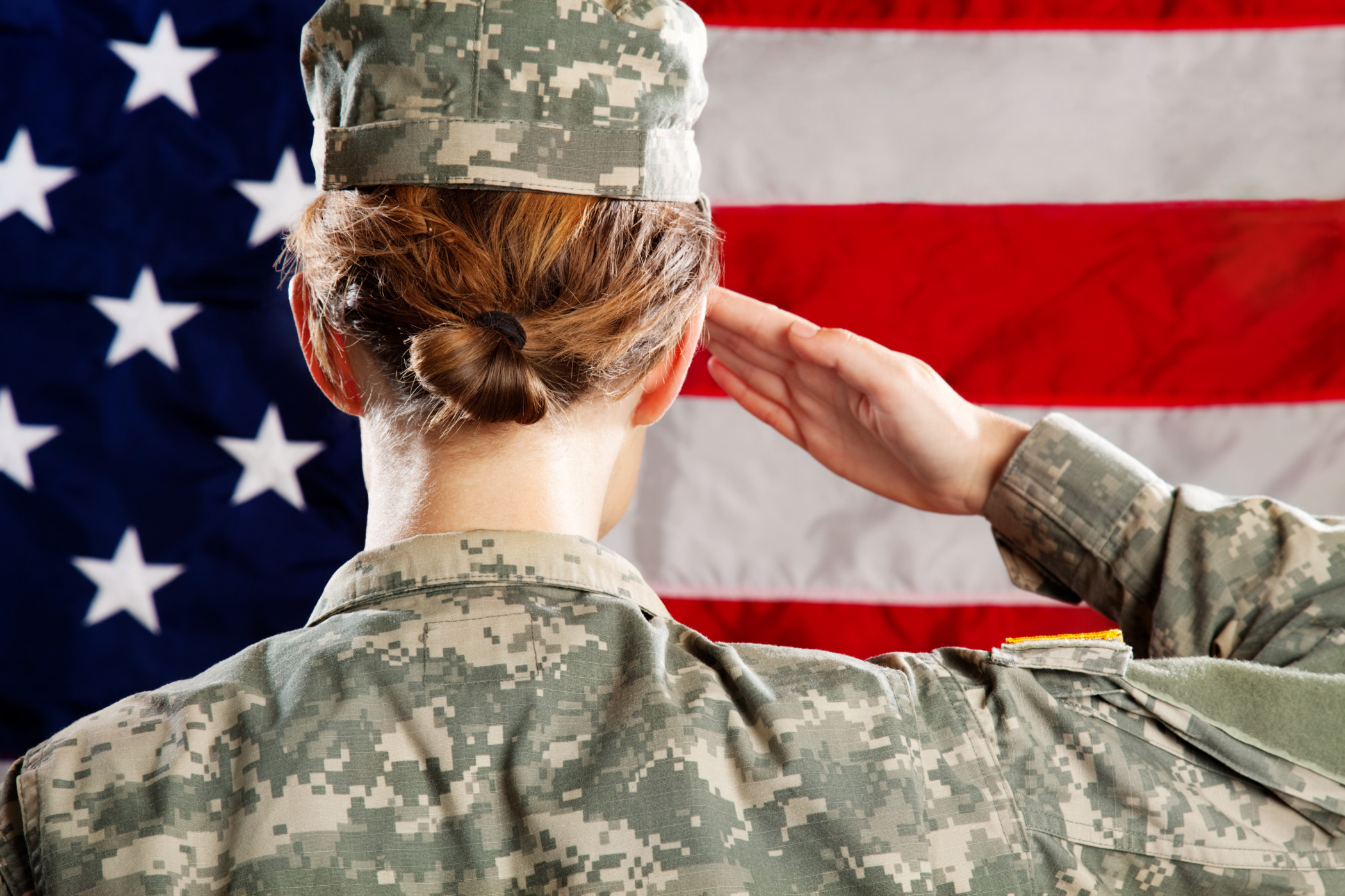 a woman in military uniform saluting in front of a flag