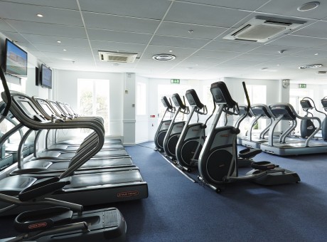 a room with exercise machines and a large window