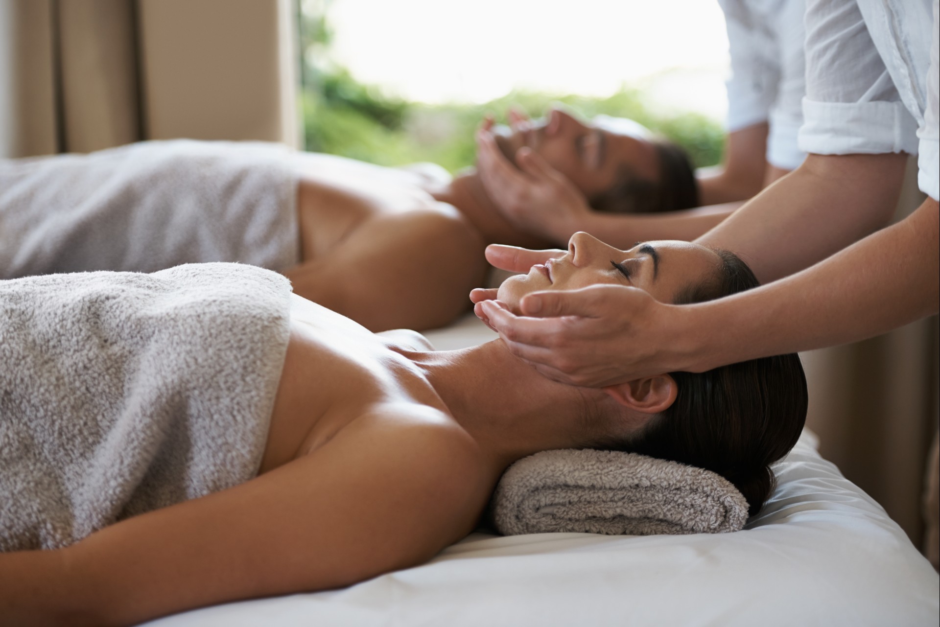 a woman and man receiving a face massage