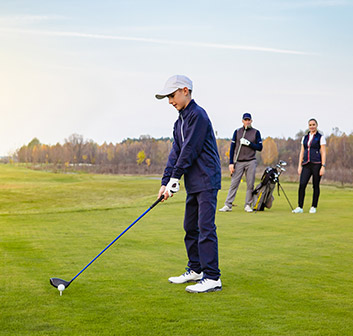 view of a man, woman and a young child golfing