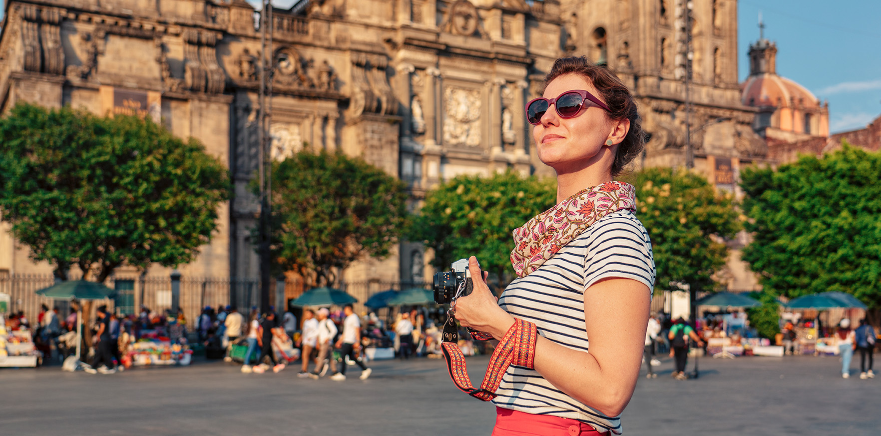 a woman holding a camera in front of a building