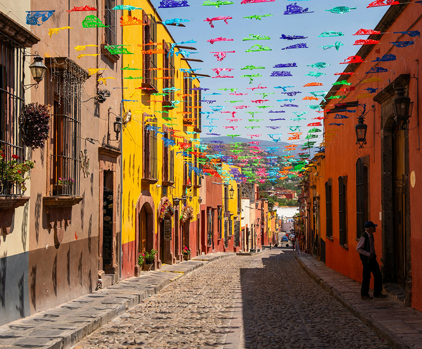 a street with colorful buildings and flags