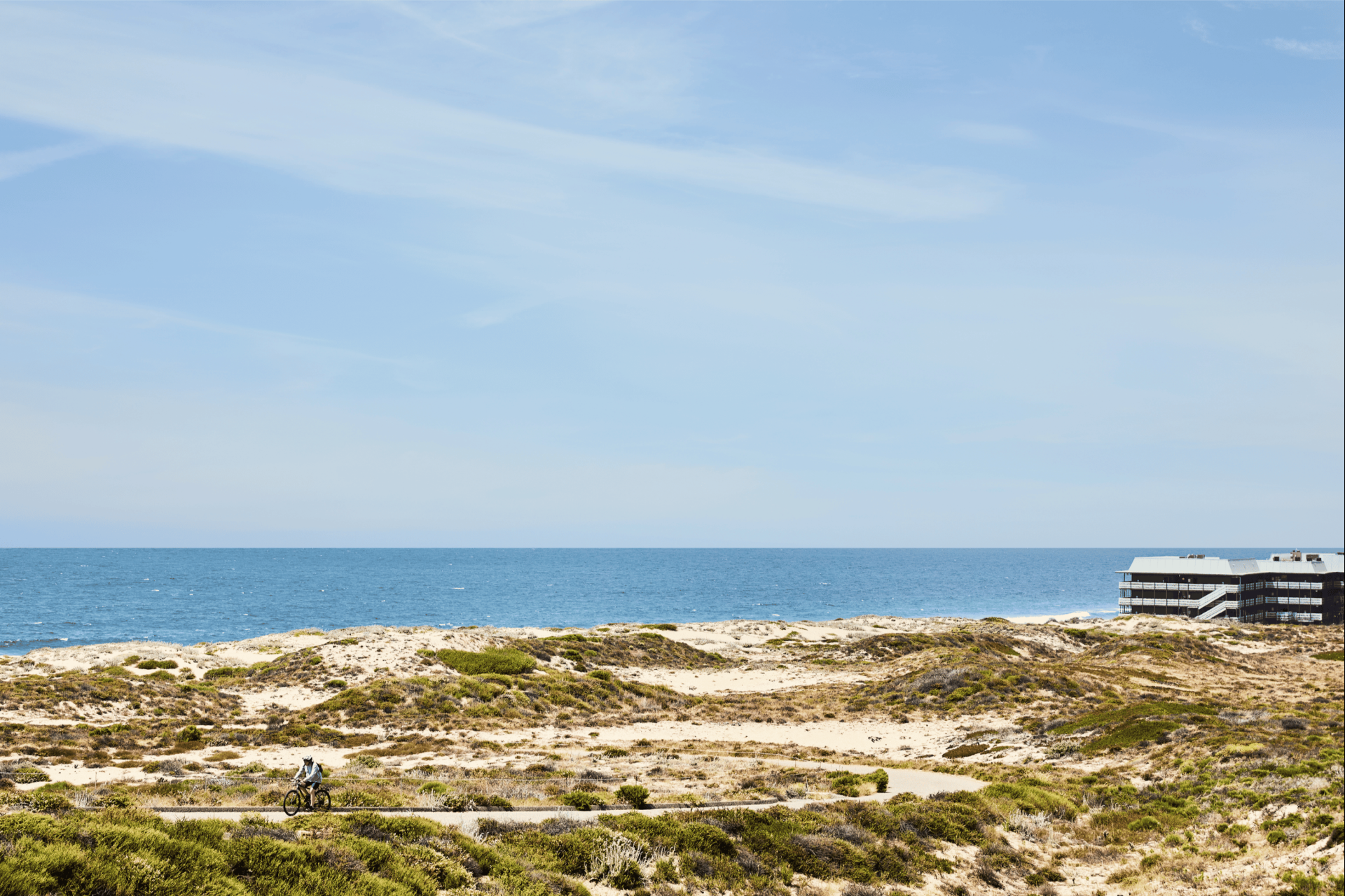 a beach with a lighthouse and a blue sky