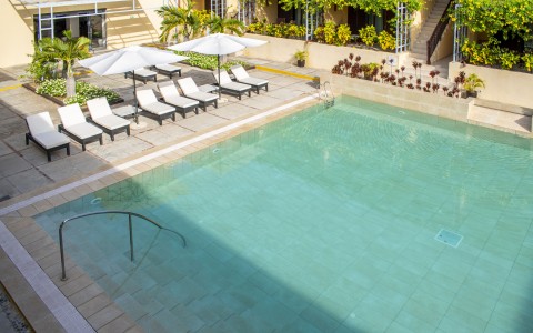 a pool with white umbrellas and chairs