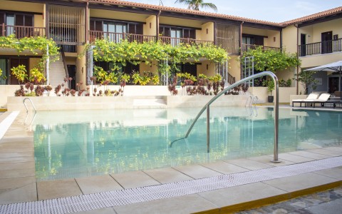 a swimming pool with stairs and stairs leading to a building