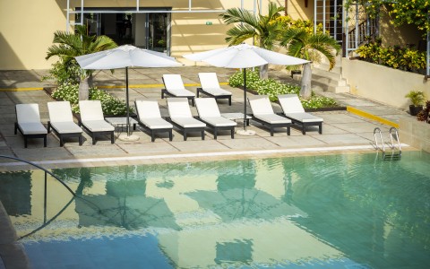 a pool with lounge chairs and umbrellas