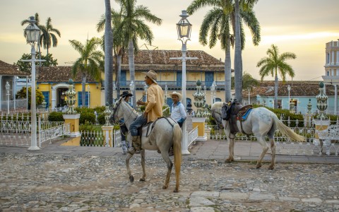 two men riding horses in a courtyard