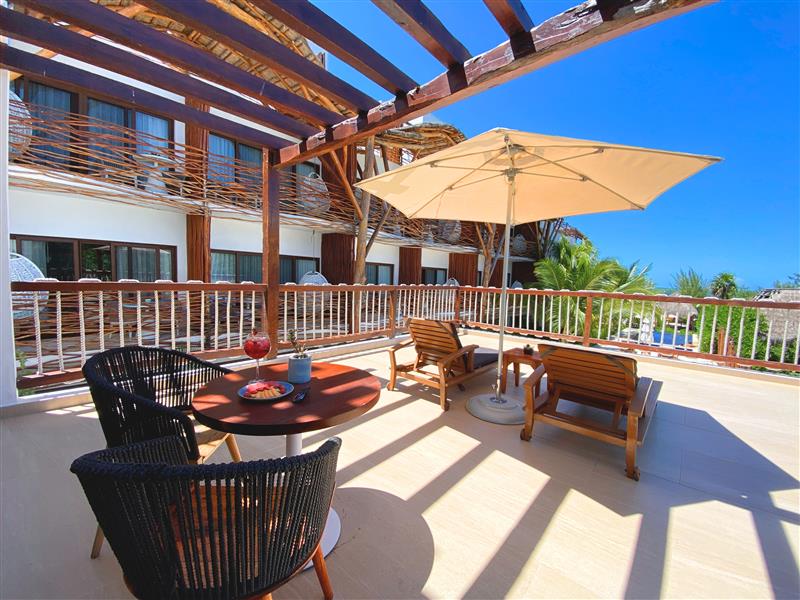 a patio with chairs and umbrella