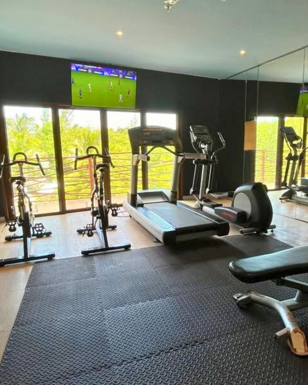 a room with exercise equipment and a television