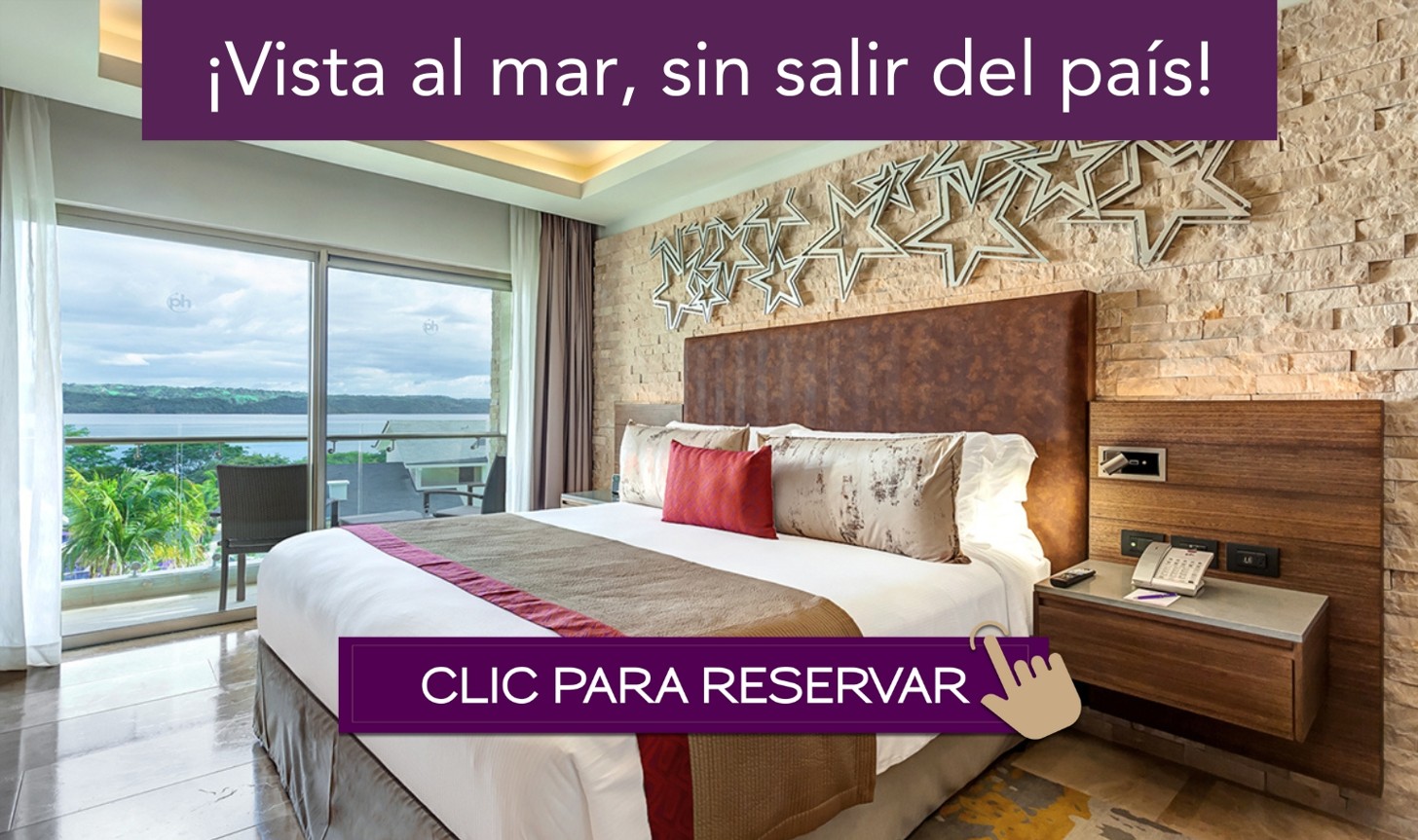 a bed with a large headboard and a window with a view of the ocean
