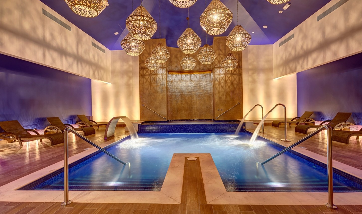 a indoor pool with water and a large chandelier