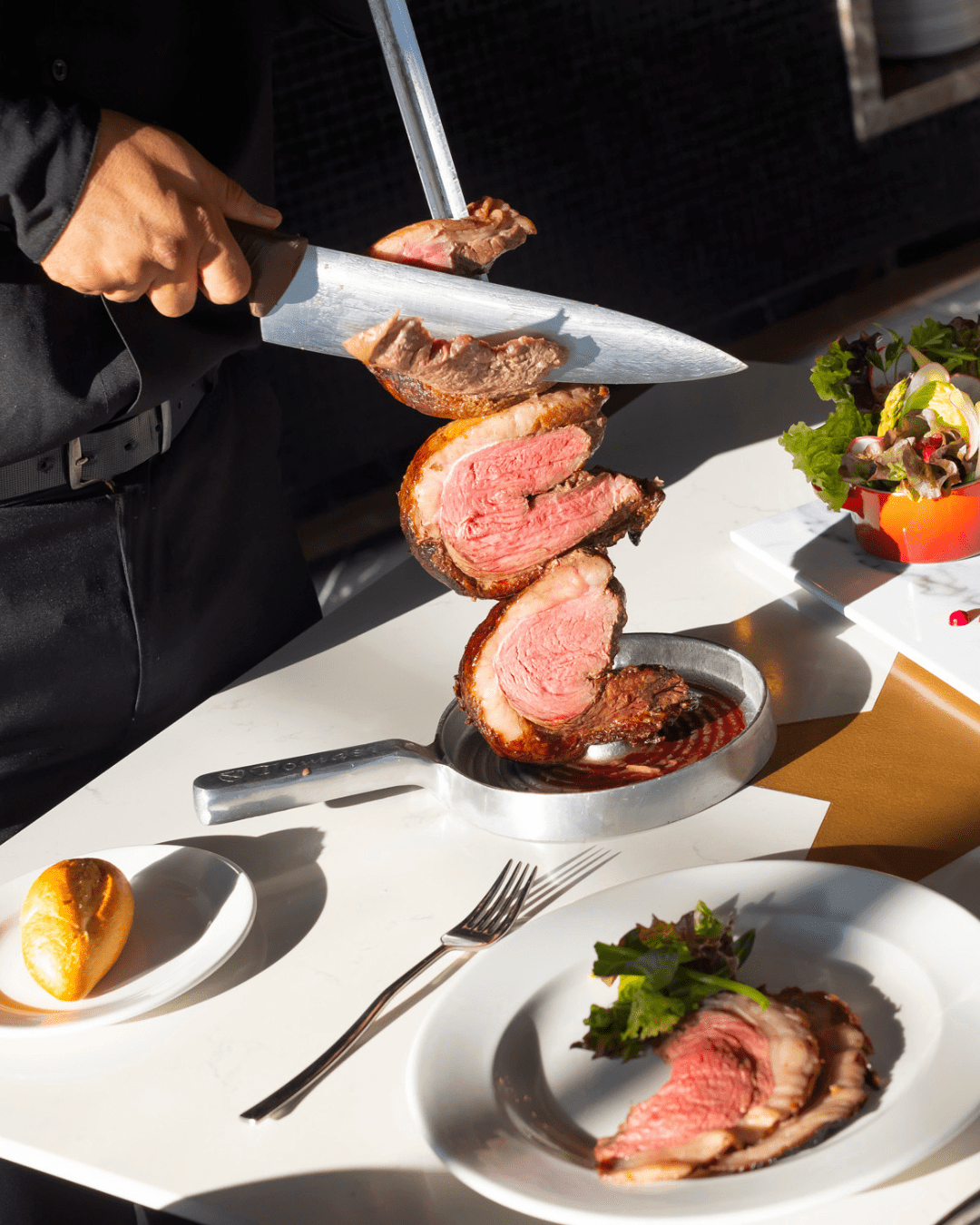 a person holding a knife over meat