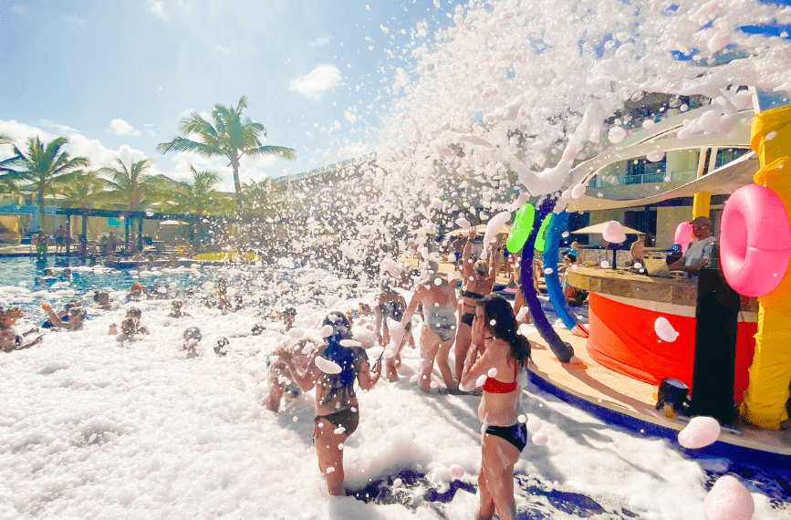 a group of people in swimsuits playing with foam