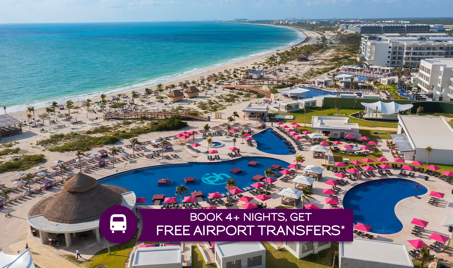 an aerial view of a beach with a swimming pool and a large body of water