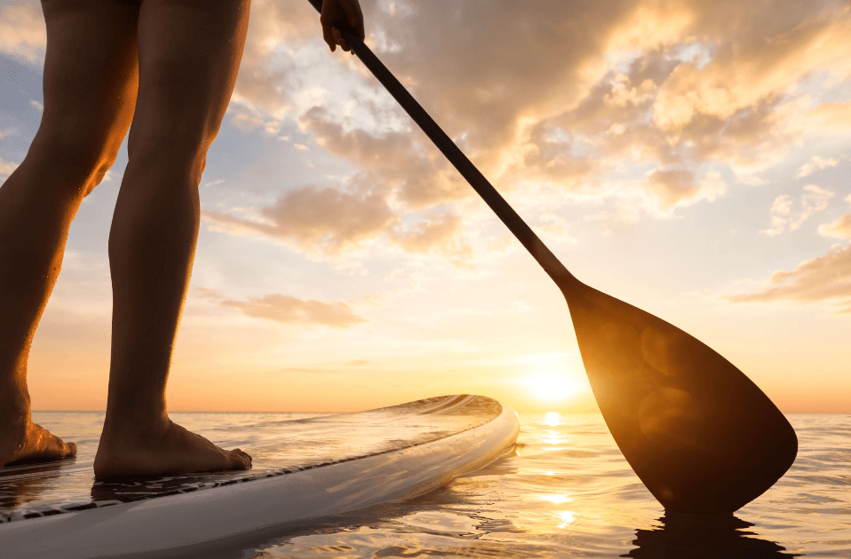 a person on a surfboard with a paddle