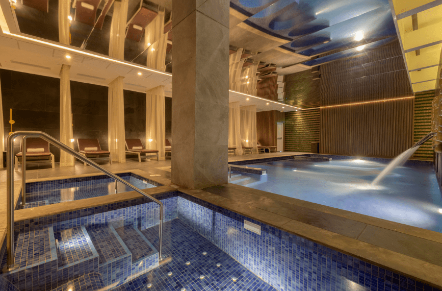 a indoor pool with a staircase and chairs